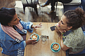 Young women friends drinking cappuccinos