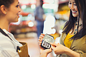 Female customer with credit card using contactless