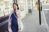 Smiling pregnant woman talking on cell phone