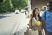 Smiling couple with shopping bag walking