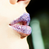 Close up purple glitter on lips of woman