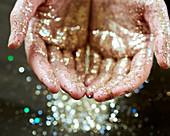 Hands cupping gold glitter