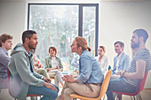 Group watching man and woman in group therapy