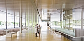 Scientists in lab coats talking lobby corridor
