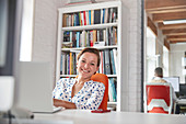Portrait businesswoman working at laptop in office