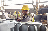 Smiling steelworker looking away in steel mill