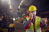 Steelworker talking, using walkie-talkie