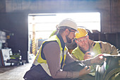 Steelworkers examining steel part in steel mill