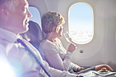 Woman drinking champagne at airplane window