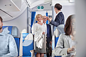 Flight attendant greeting passengers