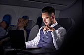 Serious businessman working on overnight airplane