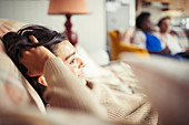 Young woman relaxing with hand in hair on sofa