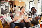 Men friends playing video game in living room
