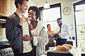 Boyfriend feeding toast to girlfriend in kitchen