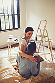 Affectionate couple hugging, painting living room