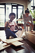 Women assembling furniture with power drill