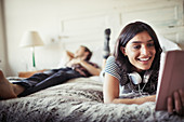 Smiling woman using digital tablet on bed