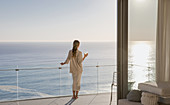Woman standing on sunny balcony