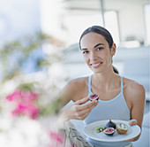 Woman eating figs and kiwi