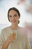Smiling brunette woman drinking juice