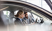 Car salesman showing car to woman