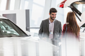 Car salesman helping customer in showroom