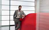 Portrait car salesman leaning on covered car