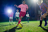 Young soccer players, kicking the ball