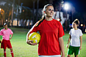 Portrait confident, young soccer player at night