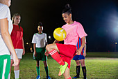 Soccer player practicing, bouncing ball on knee