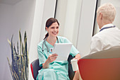 Smiling nurse talking to doctor in hospital