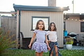 Portrait girl sisters in skirts in yard