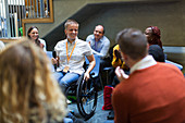 Audience listening to female speaker in wheelchair