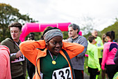 Female runner wearing medal finish line