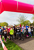 Crowd ready at charity run starting line in park