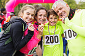 Portrait smiling, family runners showing medals