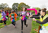 Female runner in tutu reaching for water