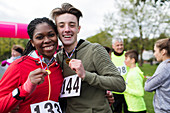 Portrait smiling, couple runners showing medals