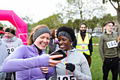Female runner friends using smart phone
