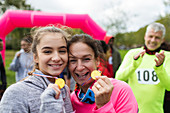 Mother and daughter runners showing medals