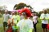 Playful boy runner in wig covered in Holi powder