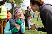 Woman in wheelchair talking to friend in park