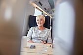 Smiling, confident businesswoman on train