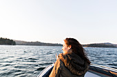 Smiling woman boating on sunny, tranquil lake