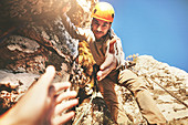 Reaching for hand of rock climber