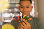 Male IT technician examining connection plugs