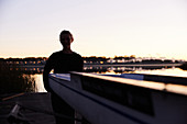 Silhouette of rower on sunrise lakeside dock