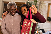 Grandson giving Christmas gift to grandfather