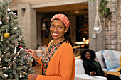 Portrait smiling woman decorating Christmas tree