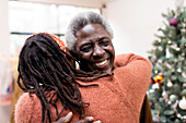 Happy senior couple hugging near Christmas tree